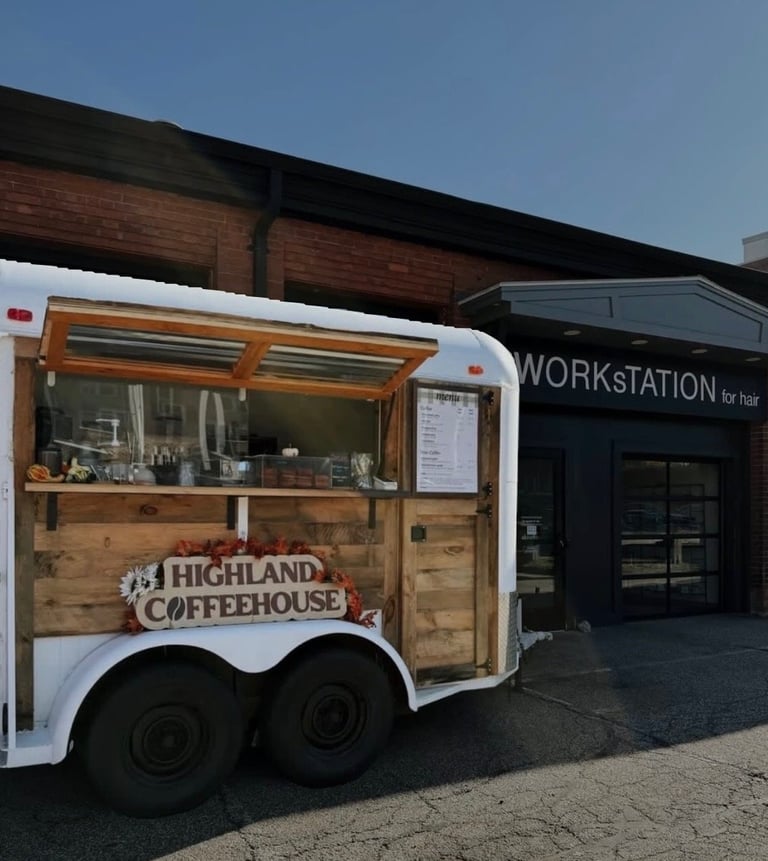 Highland Coffeehouse mobile food trailer with wooden design and service window parked outside a storefront